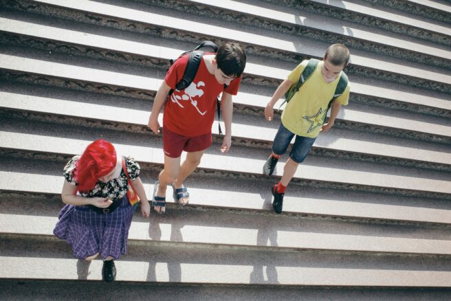 Kolme koululaista kävelemässä portaissa