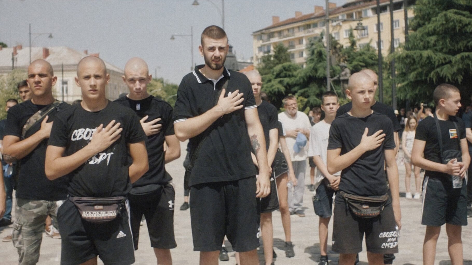 Stillkuva dokumentista Totuus vai tehtävä. Ihmisiä kokoontuneena katsomaan striimiä puhelimesta.