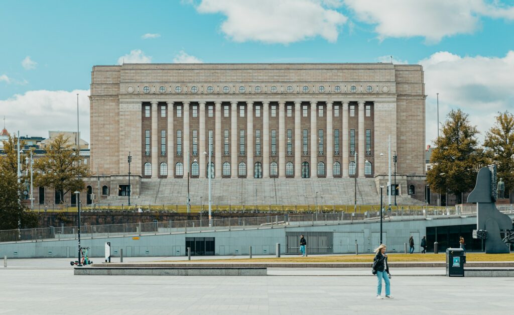 Eduskuntatalon julkisivu kirkkaana kevätpäivänä