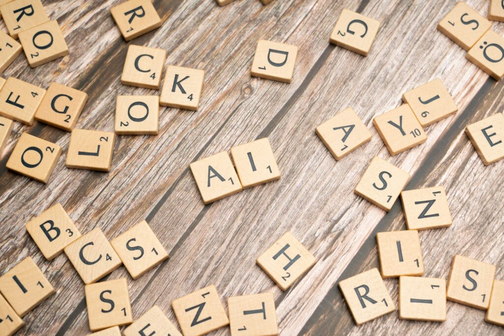 Scrabble-pelin aakkospaloja puualustalla