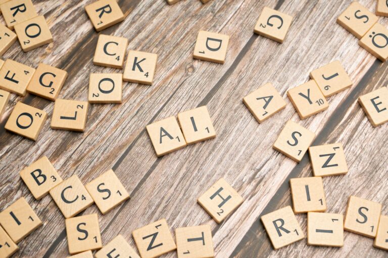 Scrabble-pelin aakkospaloja puualustalla